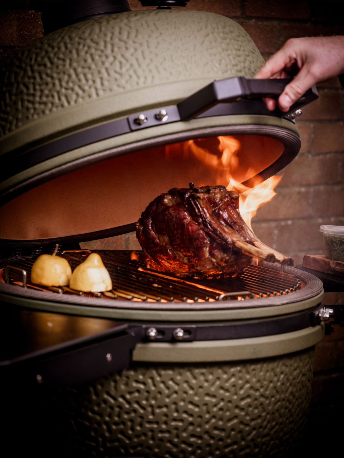 Opening a BSTRD. kamado with beef on the grate