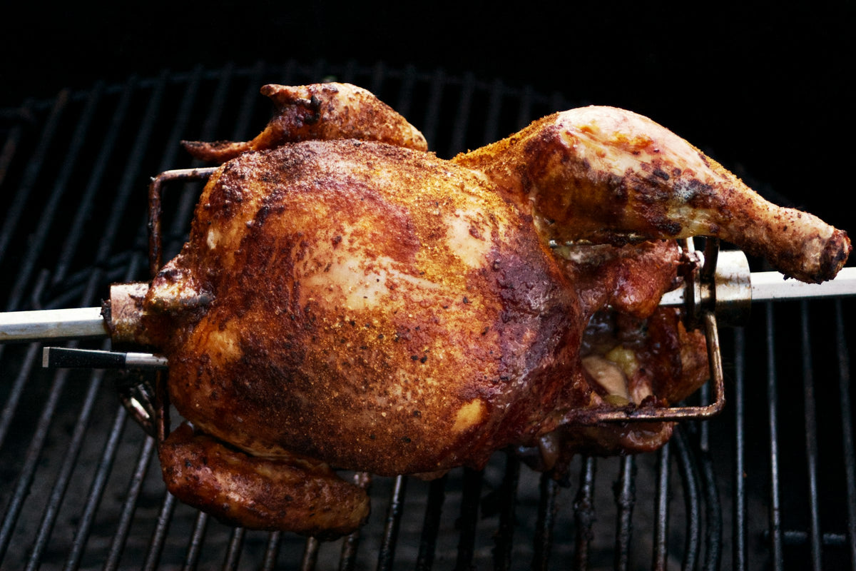 Spiced whole chicken turning over the fire