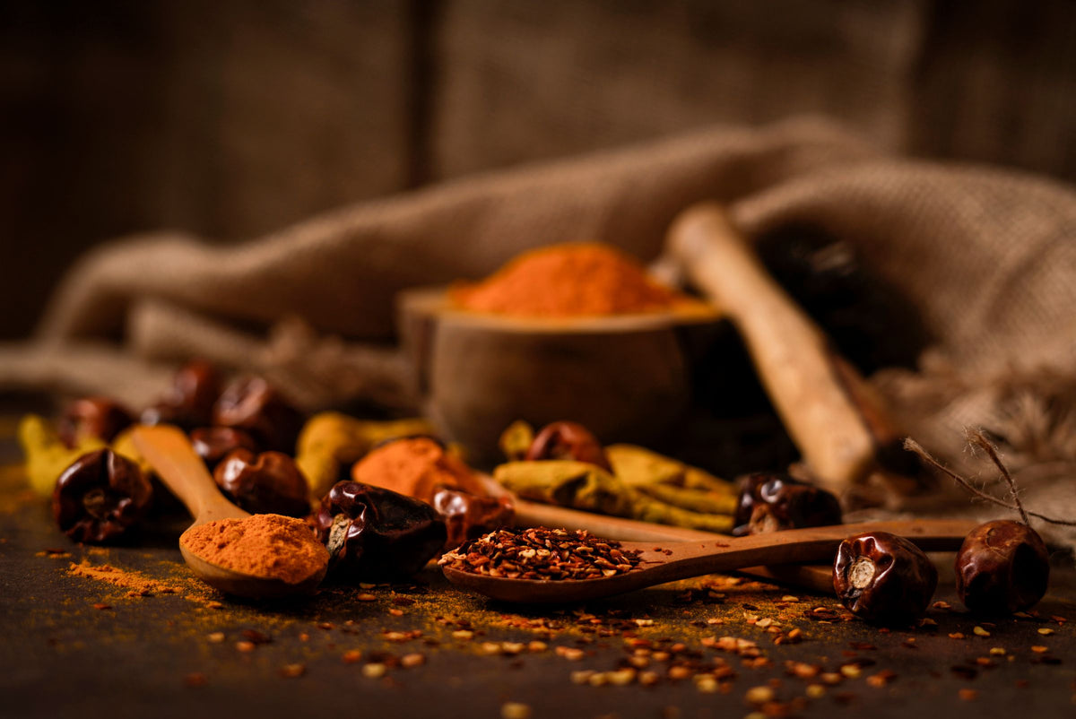 Smoked paprika and chilli on wooden spoons with dried chillies
